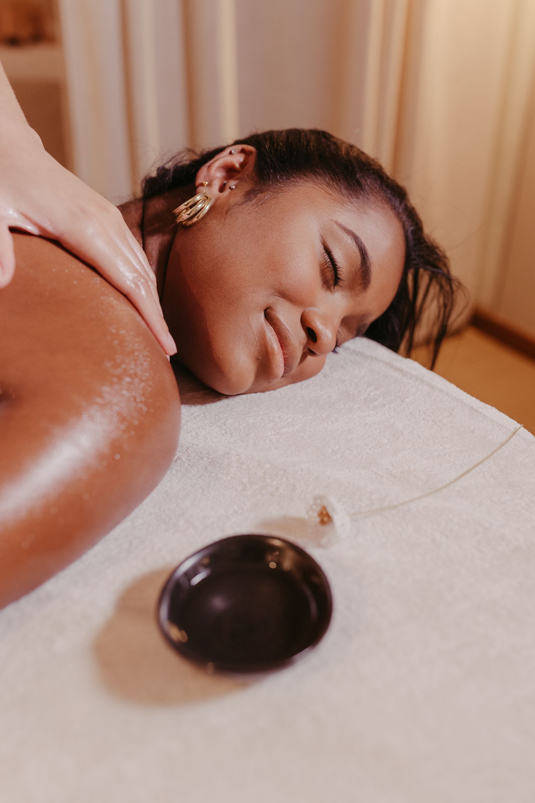 A woman enjoys a soothing massage at a spa, promoting relaxation and wellness.